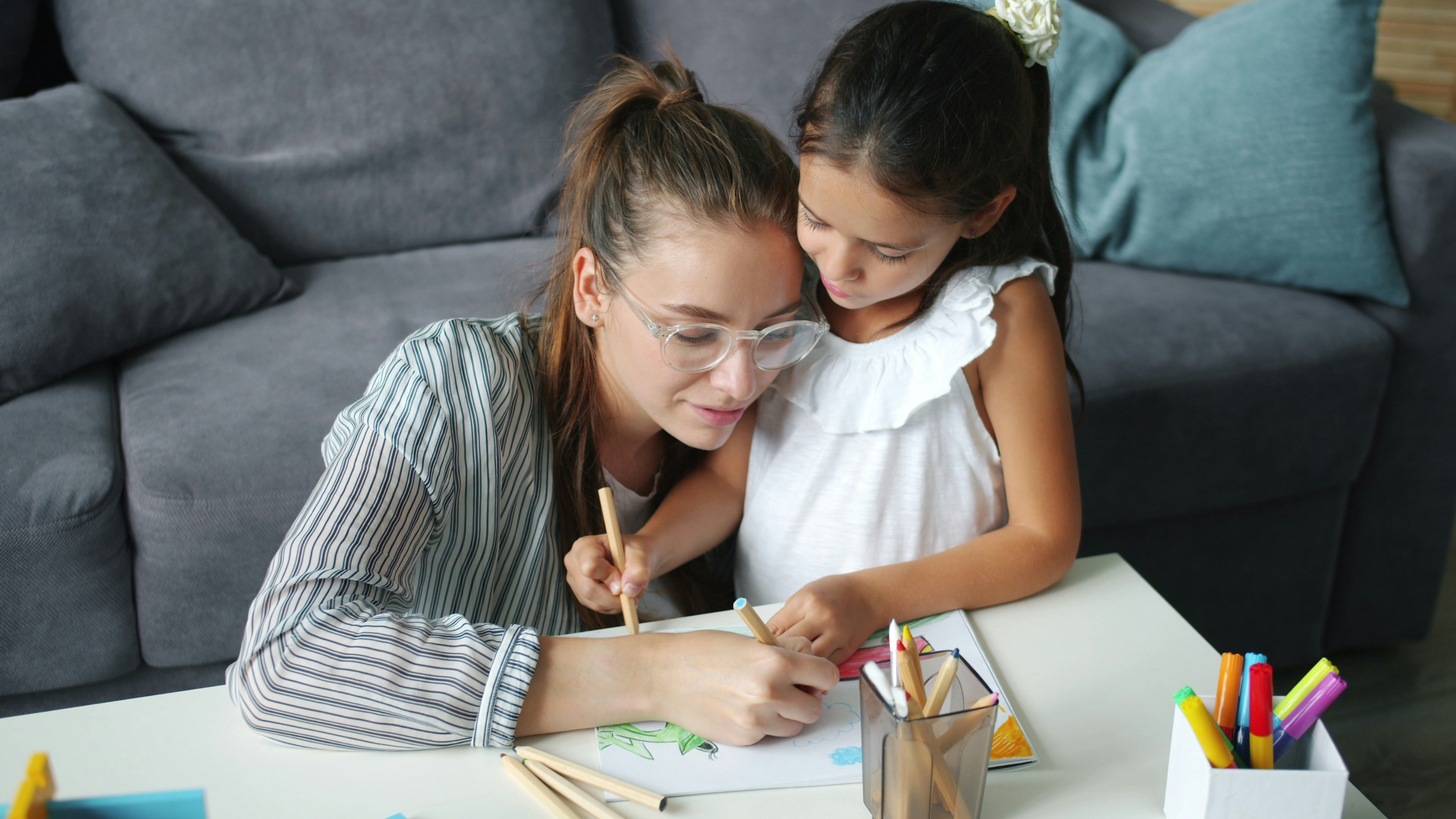 Profesional acompañando a una niña en una actividad creativa